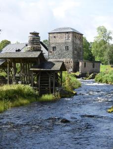 an old building sitting next to a river at Saxå Bruk in Filipstad
