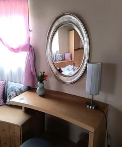 a mirror on a wall above a wooden table at Anemomilos Villa in Asprogerakata +28 photos