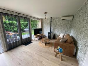 a living room with a couch and a tv at Luxury bungalow Woldzicht in Appelscha