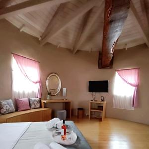 a room with a bed and a couch and two windows at Anemomilos Villa in Asprogerakata