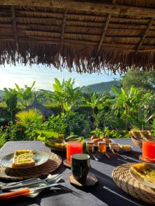 a table with food on it with a view of the jungle at Bungalow Maniry Andilana in Andilana