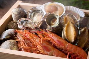 a wooden box filled with different types of seafood at Ooedo Onsen Monogatari Awazu Grand Hotel in Komatsu