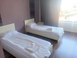 two twin beds in a room with a window at Pensiunea Casa Cora in Stupăreni