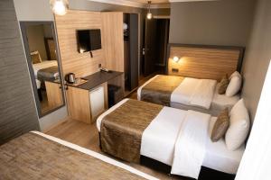 a hotel room with two beds and a mirror at Çağ Otel in Erzurum