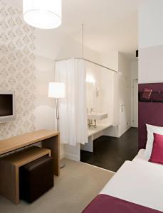 Schlafzimmer mit einem Bett, einem Schreibtisch und einem Waschbecken in der Unterkunft Hotel Zur Schonenburg in Schönberg am Kamp