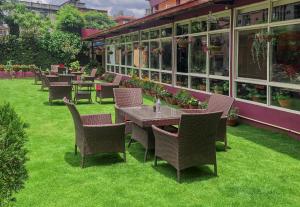 una fila di tavoli e sedie in giardino di Hotel Crown Plaza a Kathmandu