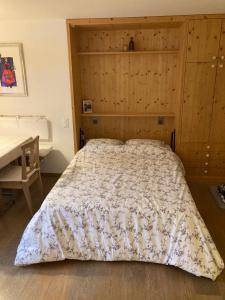 una camera da letto con un letto grande con testiera in legno di La Gemma a Celerina
