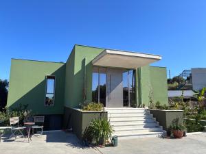 a green house with stairs and chairs in front of it at FinIQ Boutiq Studios in Foiníki