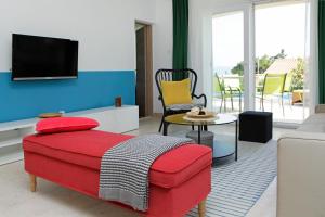a living room with a red couch and a tv at Vacation Home Villa Oleandra in Bol