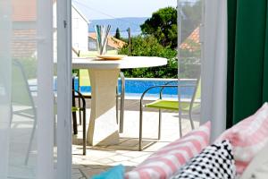 a patio with a table and chairs and a pool at Vacation Home Villa Oleandra in Bol