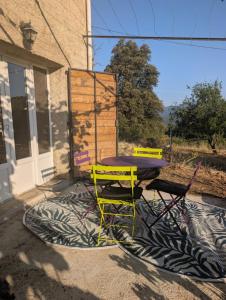 two chairs and a table on a rug in front of a house at charmant t2 in Petreto-Bicchisano +7 photos