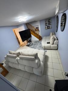 ein Wohnzimmer mit zwei Sofas und einem Fernseher in der Unterkunft Maison vacances in Saint-Mammès