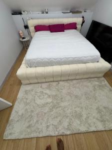 ein Schlafzimmer mit einem weißen Bett und einem Teppich in der Unterkunft Maison vacances in Saint-Mammès