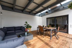 ein Wohnzimmer mit einem blauen Sofa und einem Tisch in der Unterkunft Ferienhaus Burgenland 2 in Mönchhof
