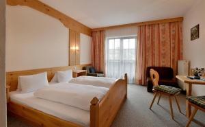 a bedroom with a large bed and a desk and chair at Haus Sebastian in Walchsee