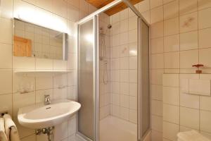 a white bathroom with a shower and a sink at Haus Sebastian in Walchsee