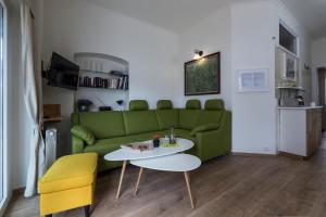 salon z zieloną kanapą i stołem w obiekcie Ferienhaus Burgenland 2 w mieście Mönchhof