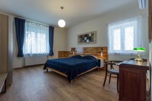 sypialnia z łóżkiem, biurkiem i oknami w obiekcie Ferienhaus Burgenland 2 w mieście Mönchhof