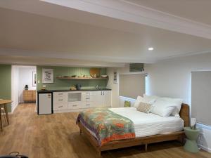 a bedroom with a bed and a kitchen at Seaside Studio in Cannonvale
