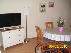 ザスニッツにあるFürstenhof - Apartment 306 Victoriaのリビングルーム(テーブル、テレビ、テーブル、椅子付)