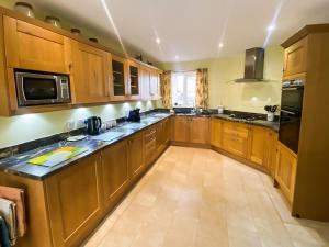 eine große Küche mit Holzschränken und -geräten in der Unterkunft Friarystone Cottage in Bamburgh