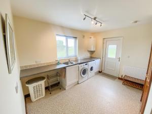 eine Küche mit Spüle und Waschmaschine in der Unterkunft Friarystone Cottage in Bamburgh