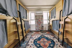伊宁Good Morning International Chain Hostel Of Yining City的一间设有双层床的房间和地毯
