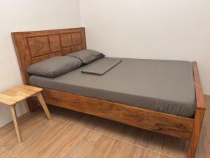 a bed with a wooden frame with a laptop on it at Casa Tres16 - Your Private Cozy Retreat in Pilar