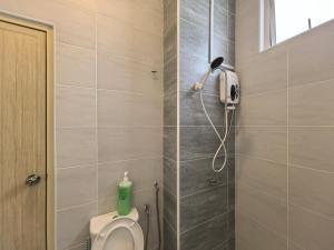 a bathroom with a toilet and a phone on the wall at Padang Serai Wangi Homestay 91 in Padang Serai