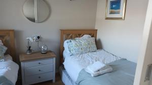 a bedroom with a bed and a dresser with a mirror at 2 Bed Apartment on the harbour in Porthmadog