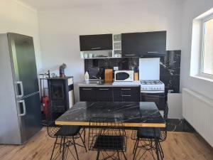 a kitchen with a table with black marble counter tops at Garden Chalet in Câmpulung