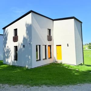 Spišské TomášovceĎurkovec Centrum的草地上一栋带黄色门的白色房子