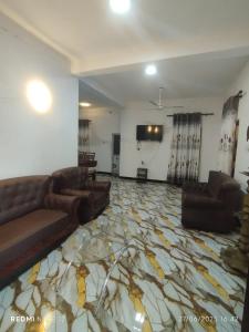 a living room with a couch and a television on a floor at Randuli Holiday Homes in Anuradhapura