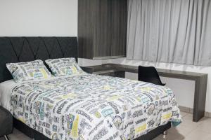a bedroom with a large bed with a desk and a bed sidx sidx at Mini Apartment in Lima