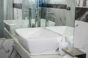 a white bathroom with a sink and a mirror at Mini Apartment in Lima