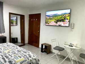 a bedroom with a bed and a tv on the wall at Mini Apartment in Lima