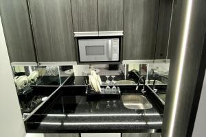 a kitchen with a sink and a microwave at Mini Apartment in Lima +3 photos
