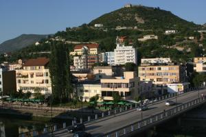 eine Stadt mit einer Brücke und einem Berg in der Unterkunft Hotel Siklad in Lezha