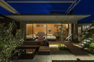 a backyard patio with two beds and a couch at 葉山Yashiro - 小型犬1匹まで一緒に泊まれる一棟貸し別荘 in Hayama