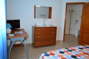 a bedroom with a desk with a computer and a bed at Apartamento na Cidade do Surf in Peniche