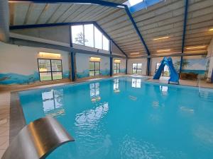 a large indoor swimming pool with a water slide at Himmerland camping & Feriecenter in Års