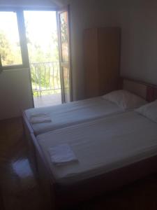 a large bed in a bedroom with a window at Apartments Oliva in Rogoznica