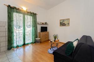 a living room with a couch and a television at Spacious Terrace Apartments in Rogoznica