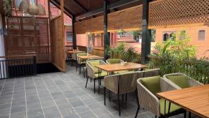un ristorante con tavoli e sedie in legno in un patio di Hotel Kailash Kutee a Kathmandu