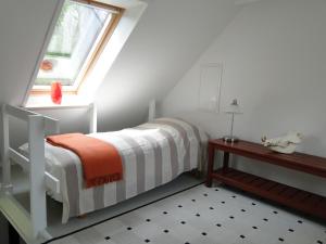 a small bedroom with a bed and a window at Dyssegaard B&B in Skallerup