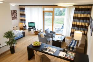 Golfresort Haugschlag في Haugschlag: غرفة معيشة مع أريكة وطاولة