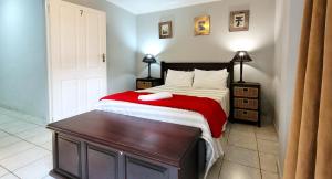 a bedroom with a bed with a red and white blanket at LookOut Ramsgate in Ramsgate