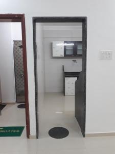 an open door into a kitchen with a microwave at Spanish villa , chinchoti in Bapane
