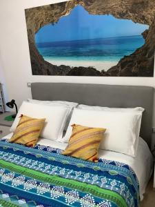 a bedroom with a bed with a picture of the ocean at exclusive house in Cala Gonone