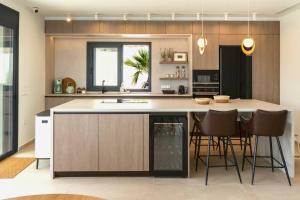 a kitchen with a large island with bar stools at Premium Collection Villas in Vouliagmeni Lake